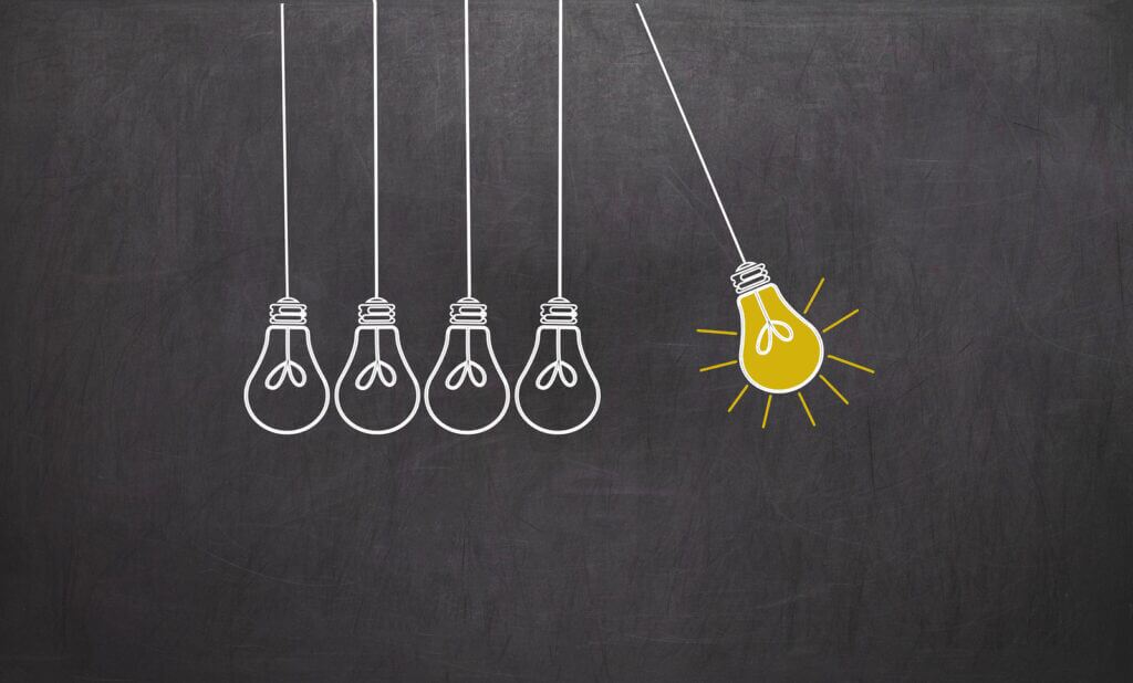 Creativity concept with light bulbs on chalkboard background