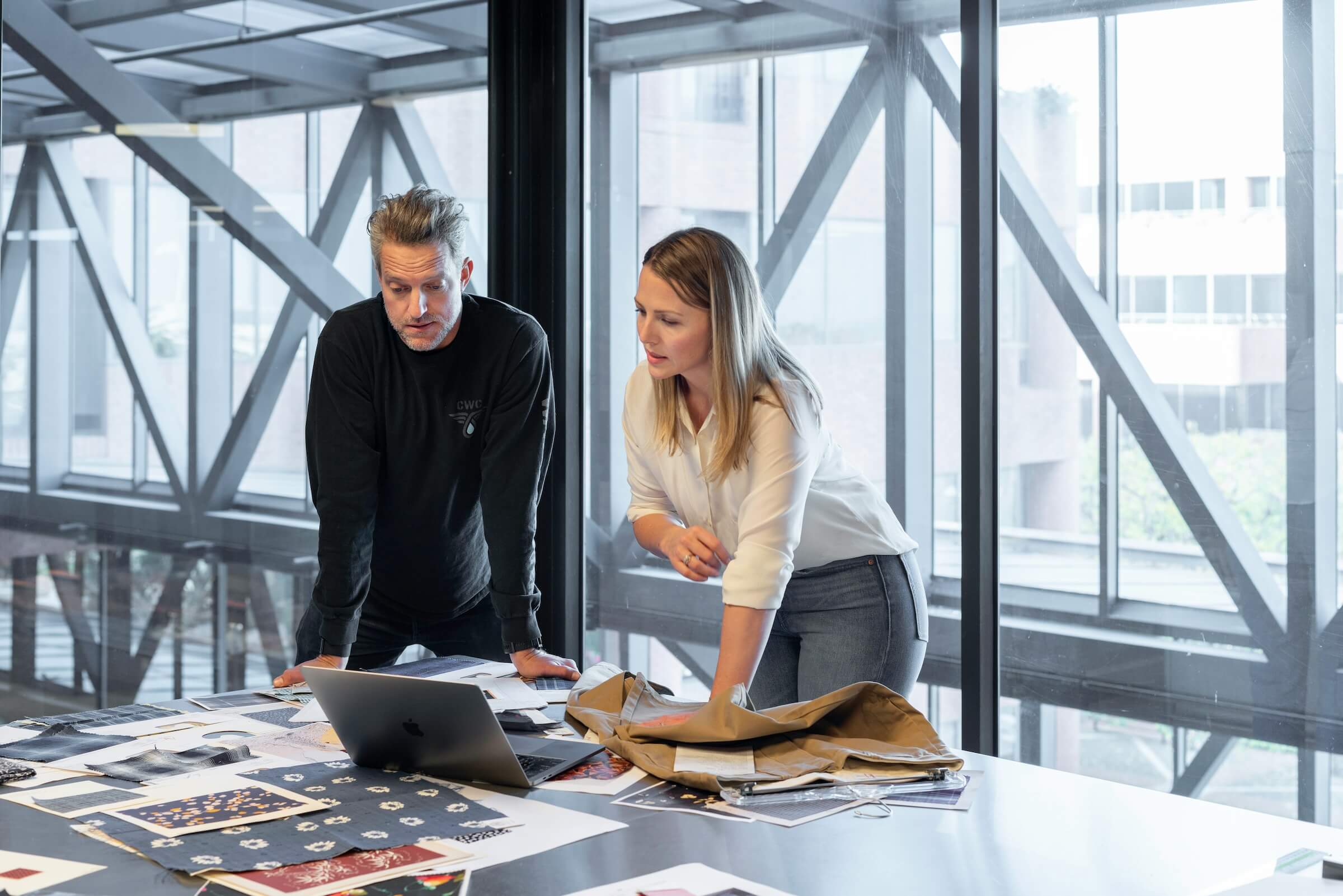 Two colleagues reviewing documents at a table in a bright modern office