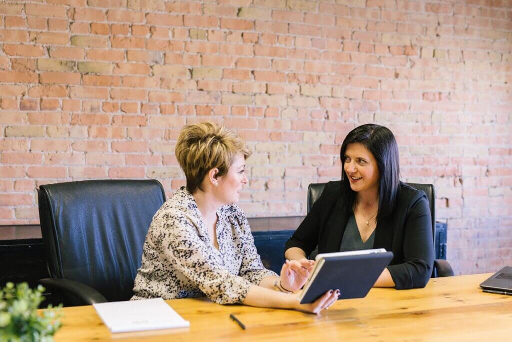 Two women reviewing a tablet at a desk