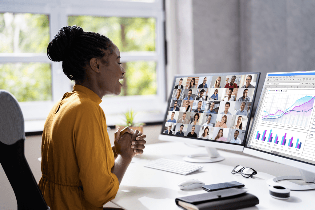 Woman on a video call at a desk with multiple monitors