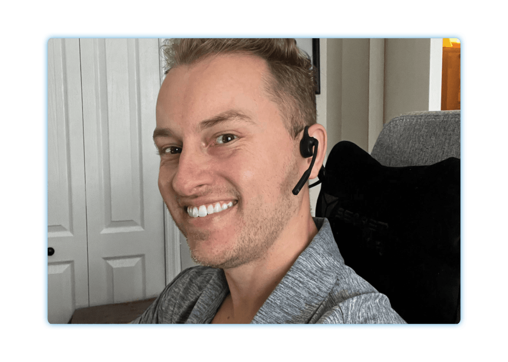 Man wearing a headset smiling at his desk
