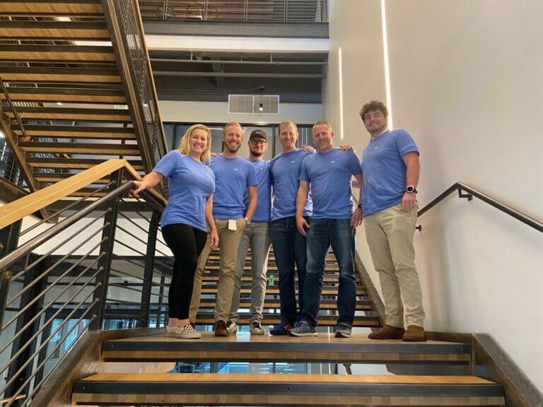 HRSoft team wearing branded t-shirts on a staircase