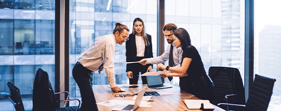 Business team meeting around a table by large office windows