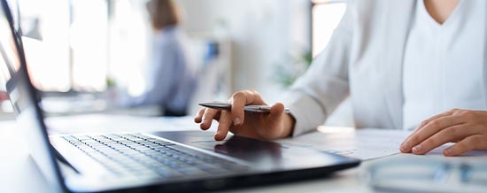 Close-up of a person typing on a laptop during a meeting