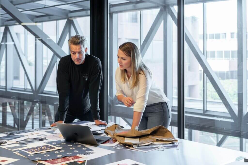 Two colleagues reviewing documents at a table in a bright modern office