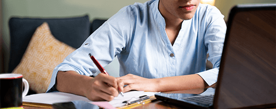 Woman writing in a notebook at a desk