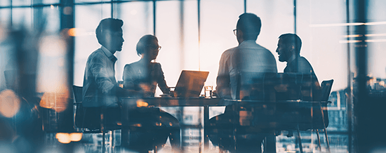 Silhouettes of business professionals meeting around a table